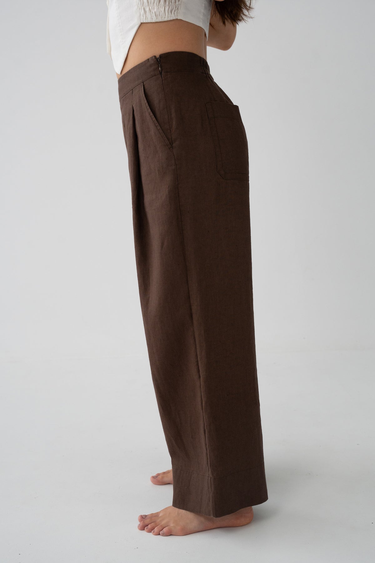 Ivy Linen Crop Pants in Chocolate - side close-up showing front pleat and wide-leg linen drape, studio backdrop - Lilly Pilly Collection