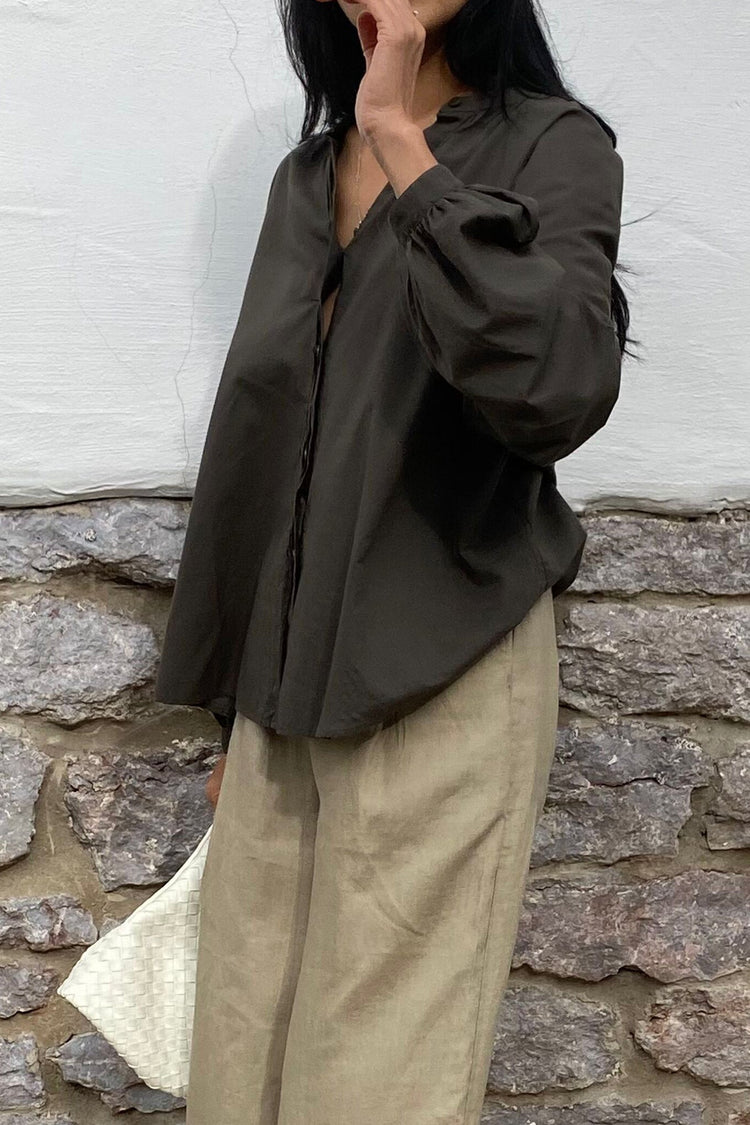 Ember Cotton Voile Shirt in Khaki - close-up, gathered cuff detail, hand raised to face, brick wall backdrop - Lilly Pilly Collection