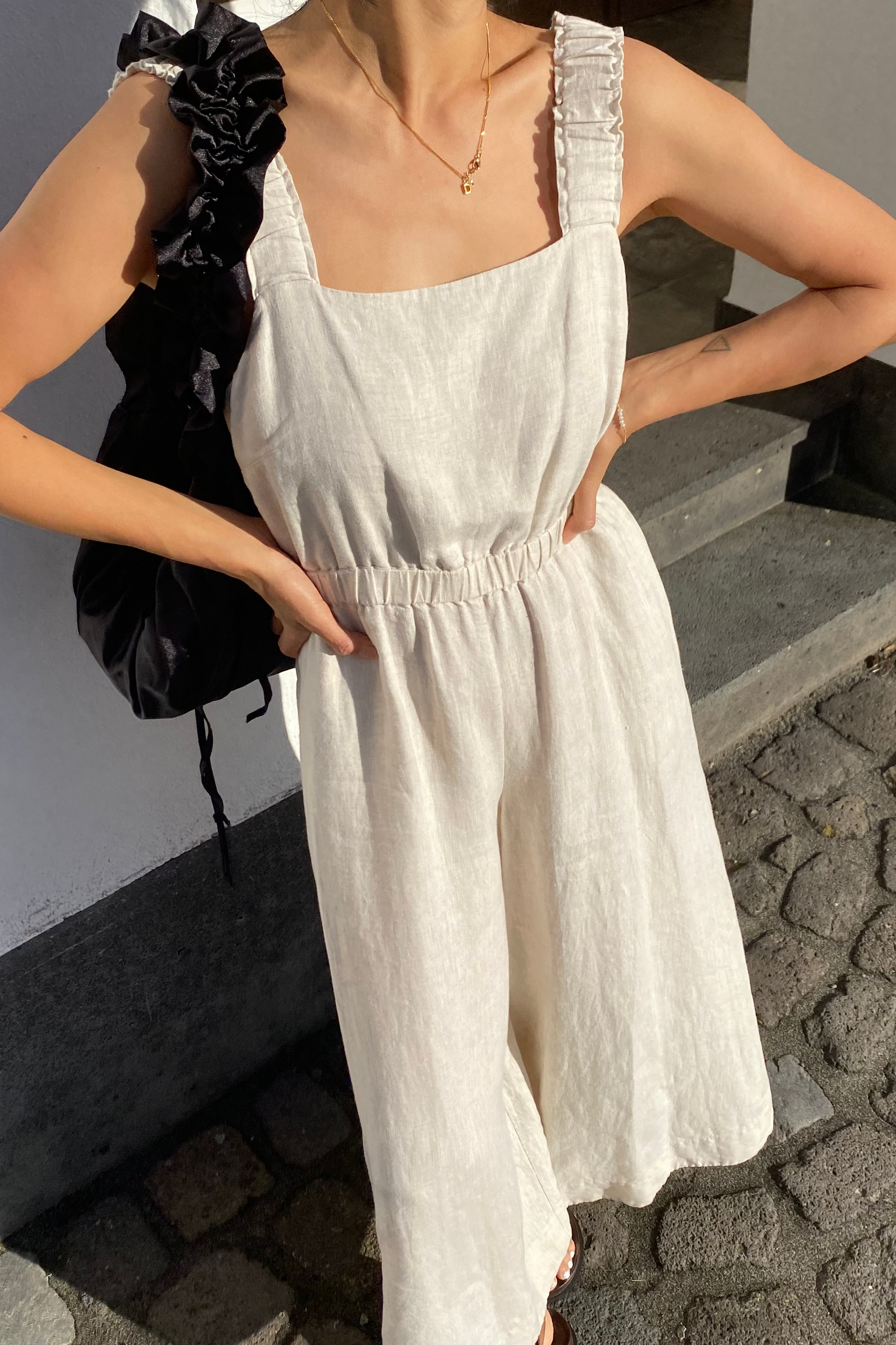 Close-up of a woman wearing the Keely Linen jumpsuit in Oatmeal - Lilly Pilly Collection