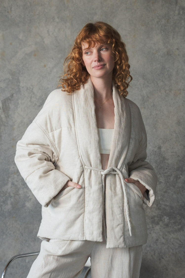 Aster Linen Coat in Oatmeal - front view, shawl collar and tie-front detail, worn over cream trousers, studio setting - Lilly Pilly Collection