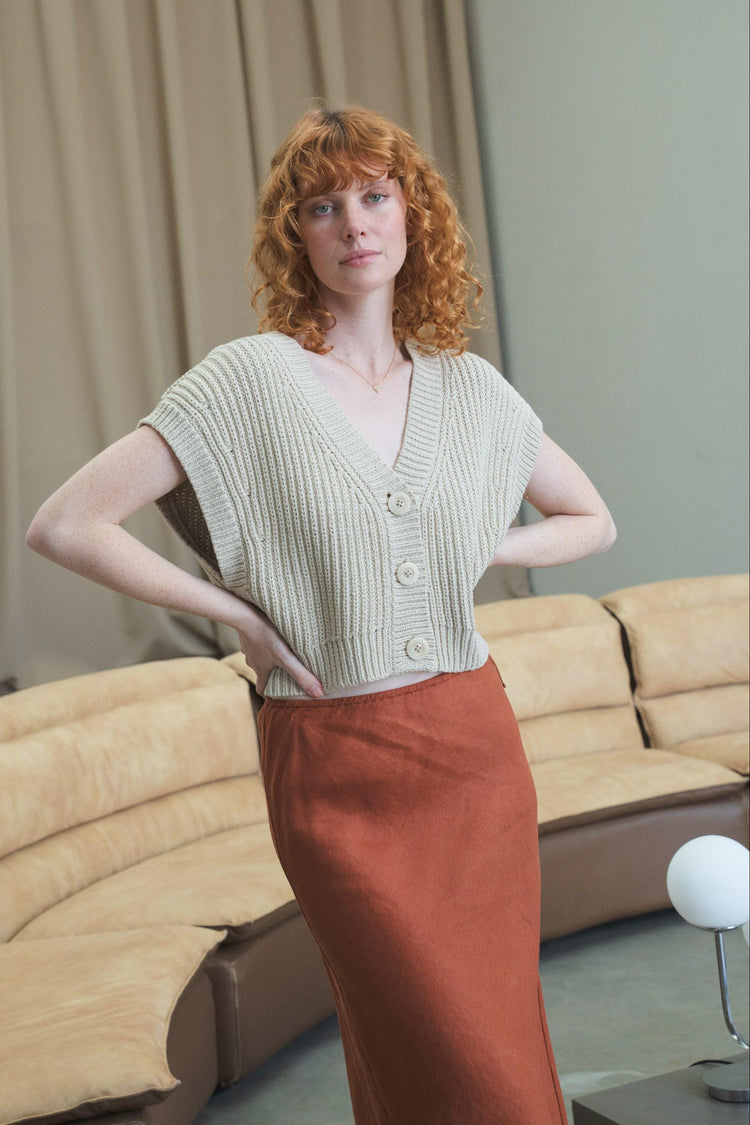 Elara Cotton Vest in Husk Grey - front view, V-neckline and button-front, hand on hip, studio setting - Lilly Pilly Collection