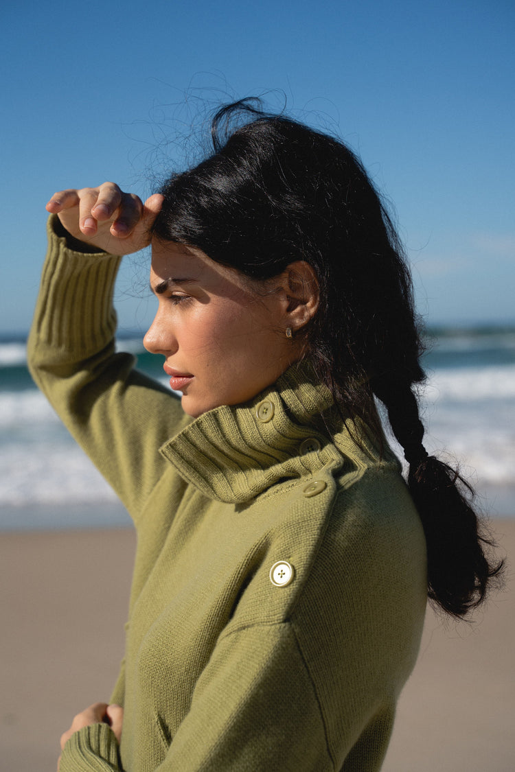 Kaida Cashmere Knit in Olive - close up view of neckline details by the ocean waves - Lilly Pilly Collection