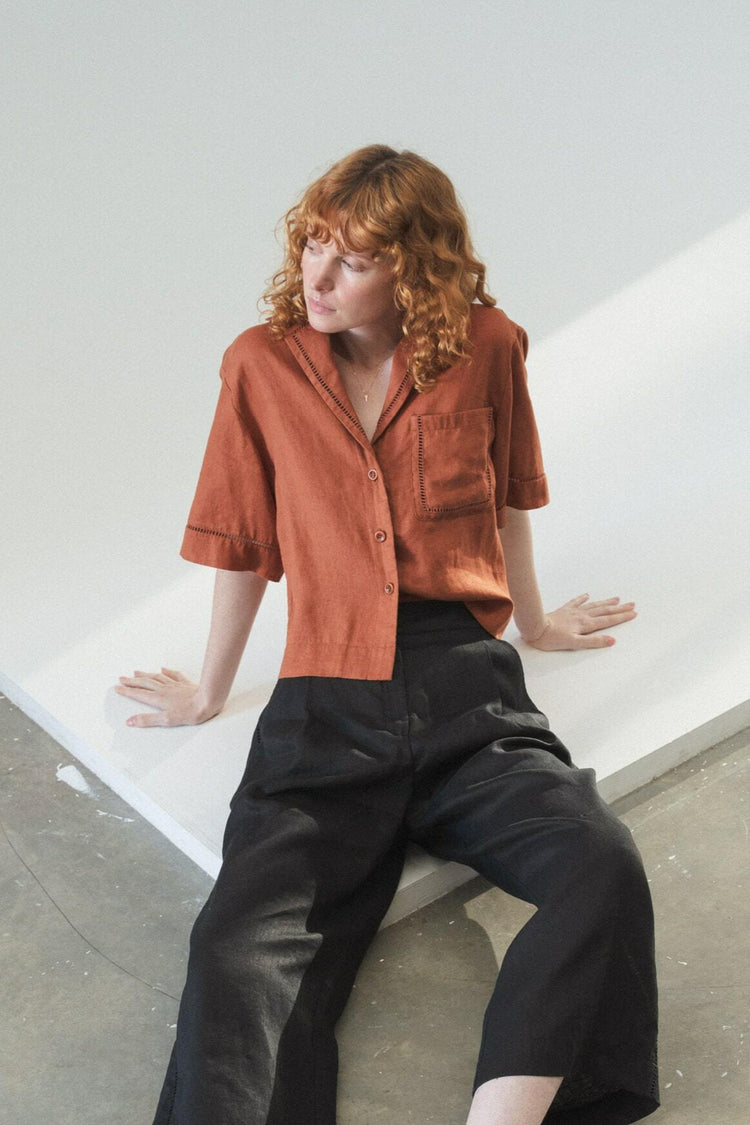 Quinn Linen Shirt in Cajun Red - front view seated paired with black Oli pants - Lilly Pilly Collection
