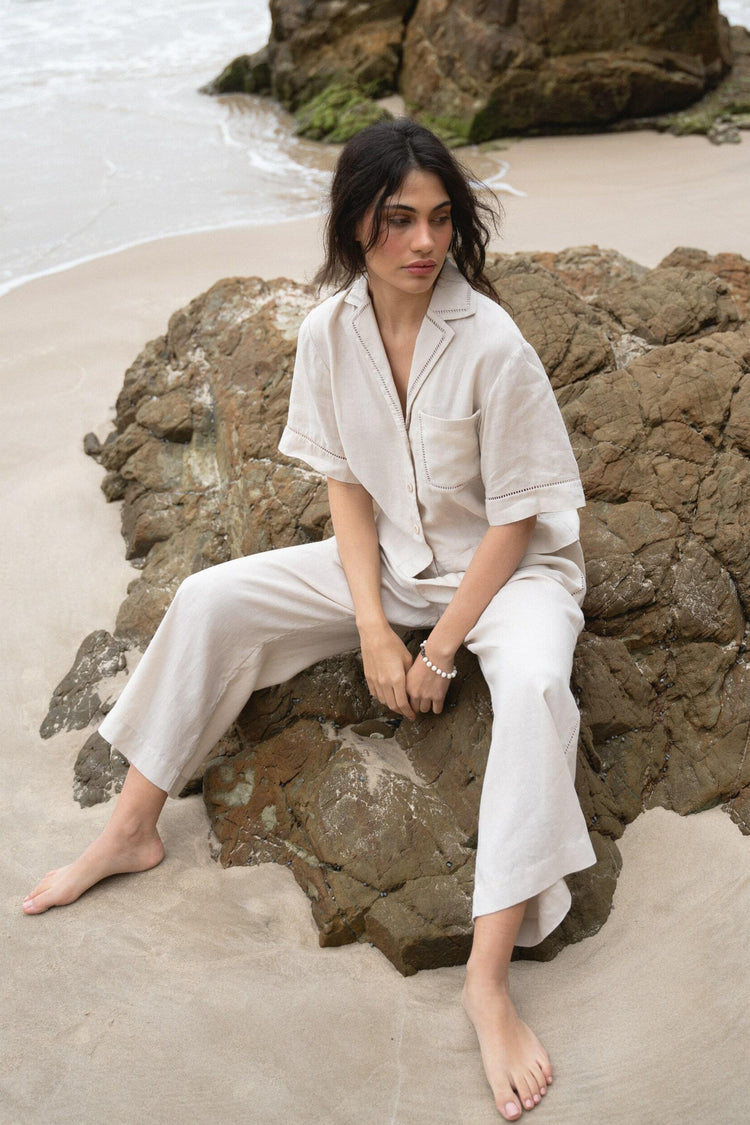 Quinn Linen Shirt in Chalk White - front view while seated on the rocks, paired with matching Rika pants - Lilly Pilly Collection