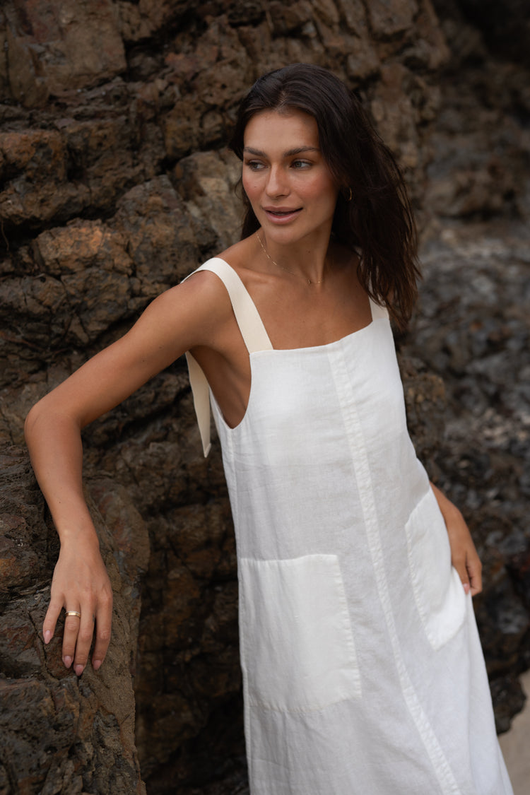 Remi Linen Dress in Ivory - close up side view standing on the beach - Lilly Pilly Collection