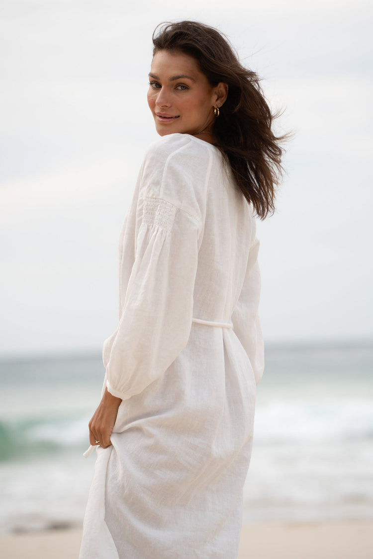 Skylar Linen Dress in Ivory - side view while standing on the beach - Lilly Pilly Collection