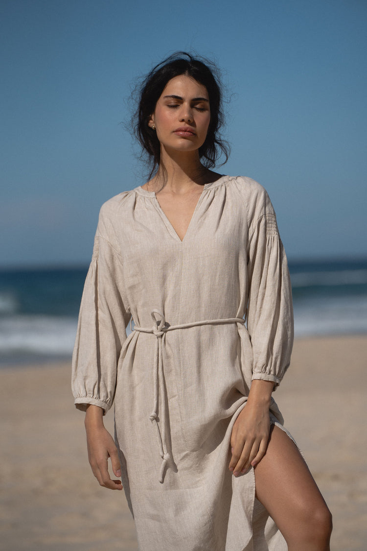Skylar Linen Dress in Oatmeal - front view while standing on the beach - Lilly Pilly Collection