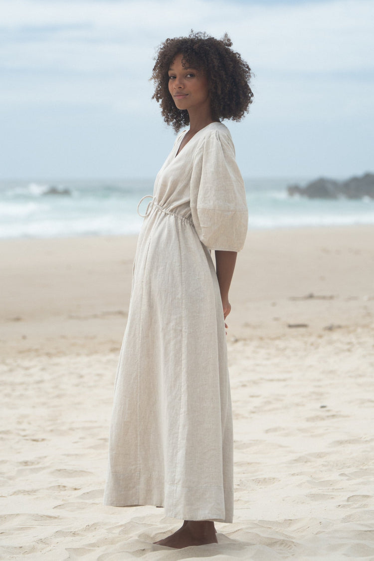 Side view of a woman wearing the Vida Linen maxi sleeve dress in Oatmeal - Lilly Pilly Collection
