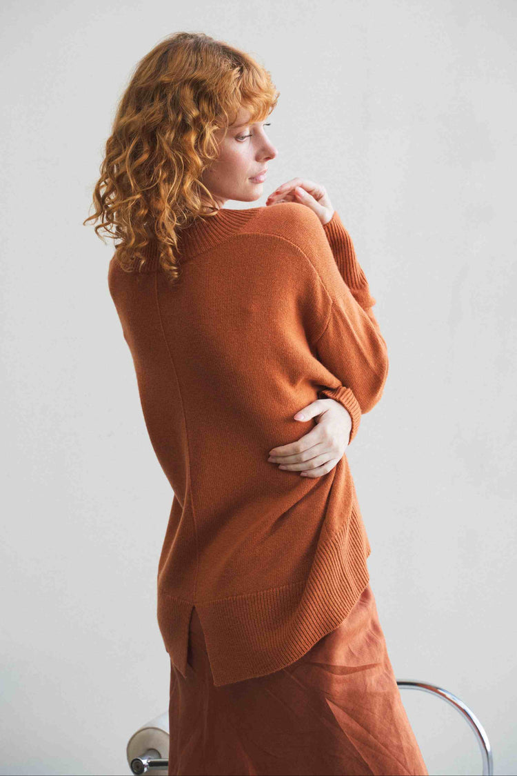 June Cashmere Knit in Cajun Red - close-up back view, split hem detail, studio setting - Lilly Pilly Collection