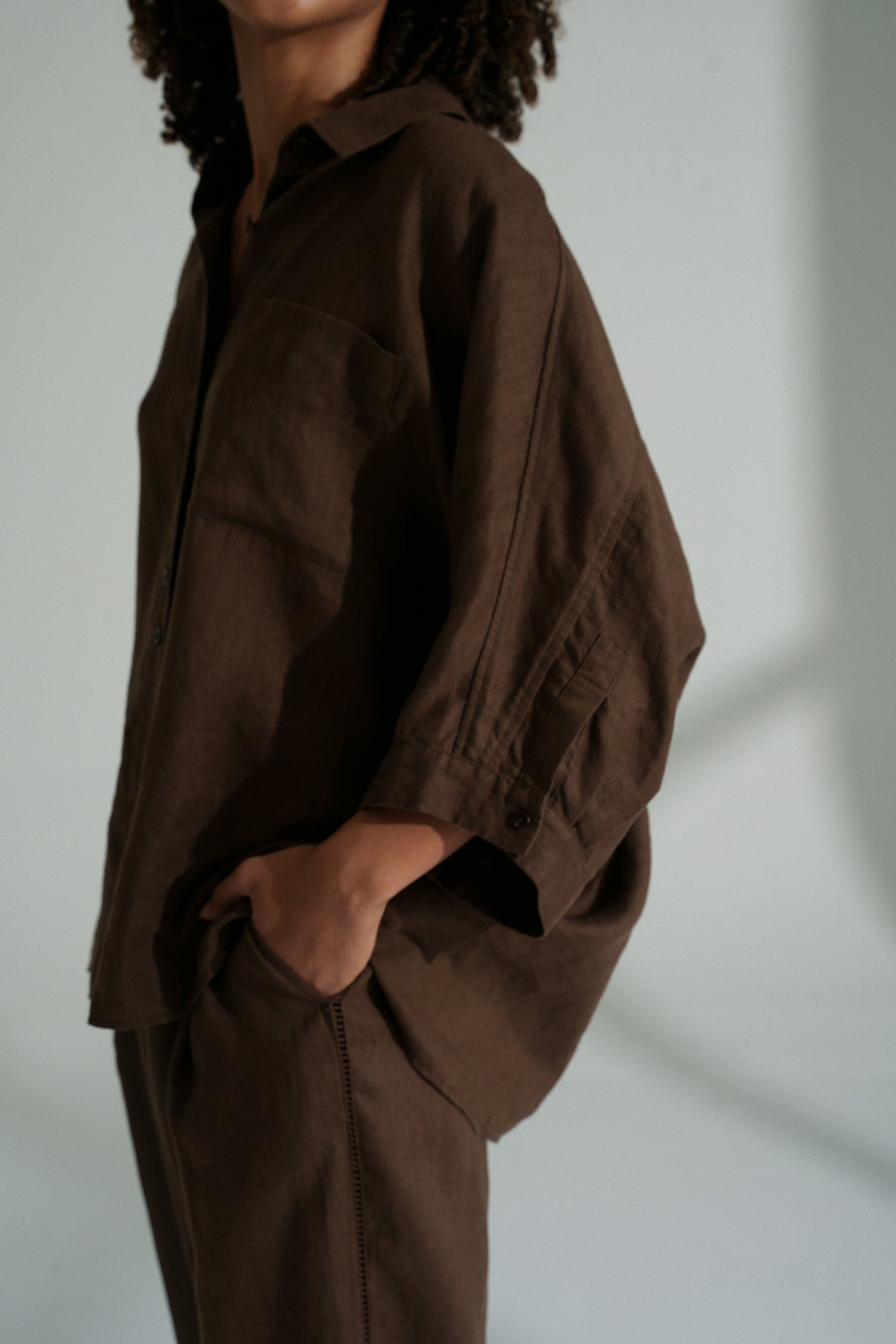 LILLY PILLY woman wearing a chocolate brown Pixie linen shirt and linen pants set showing close up of the sleeves