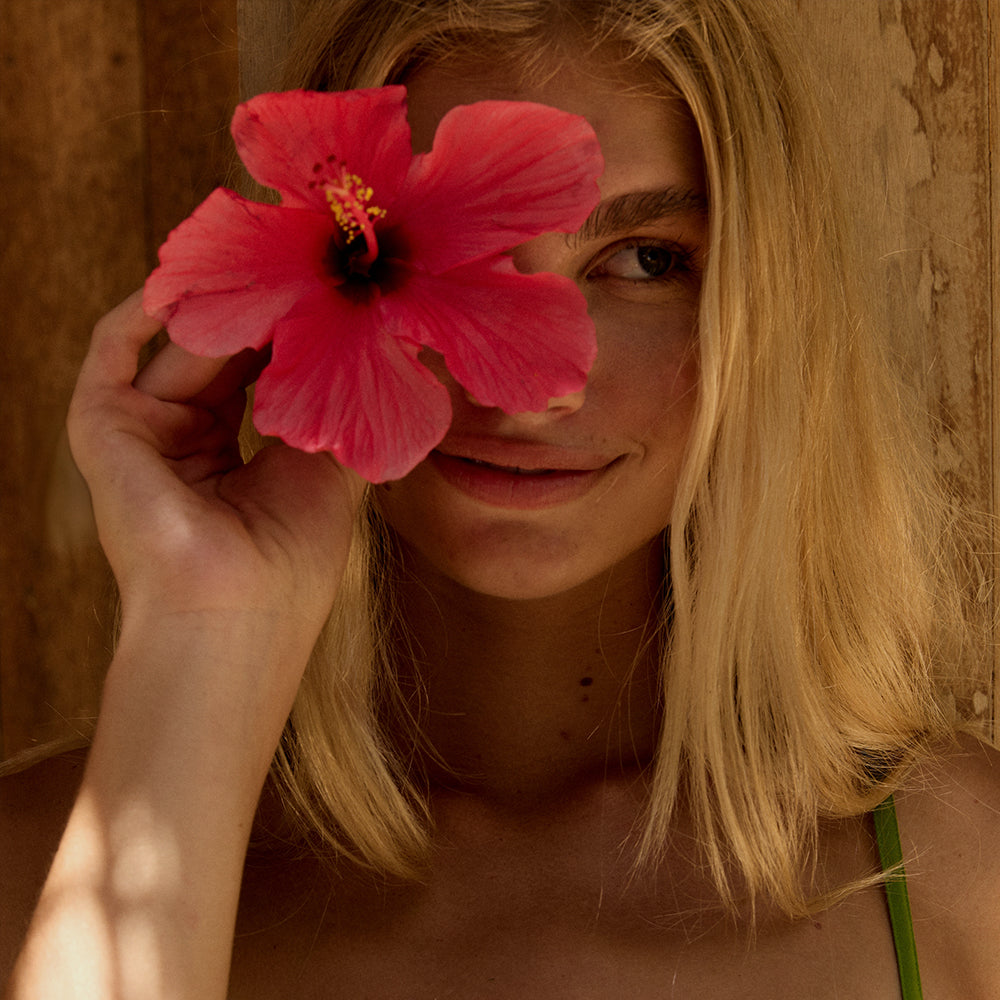 Lilly Pilly woman holding a hibiscus flower 