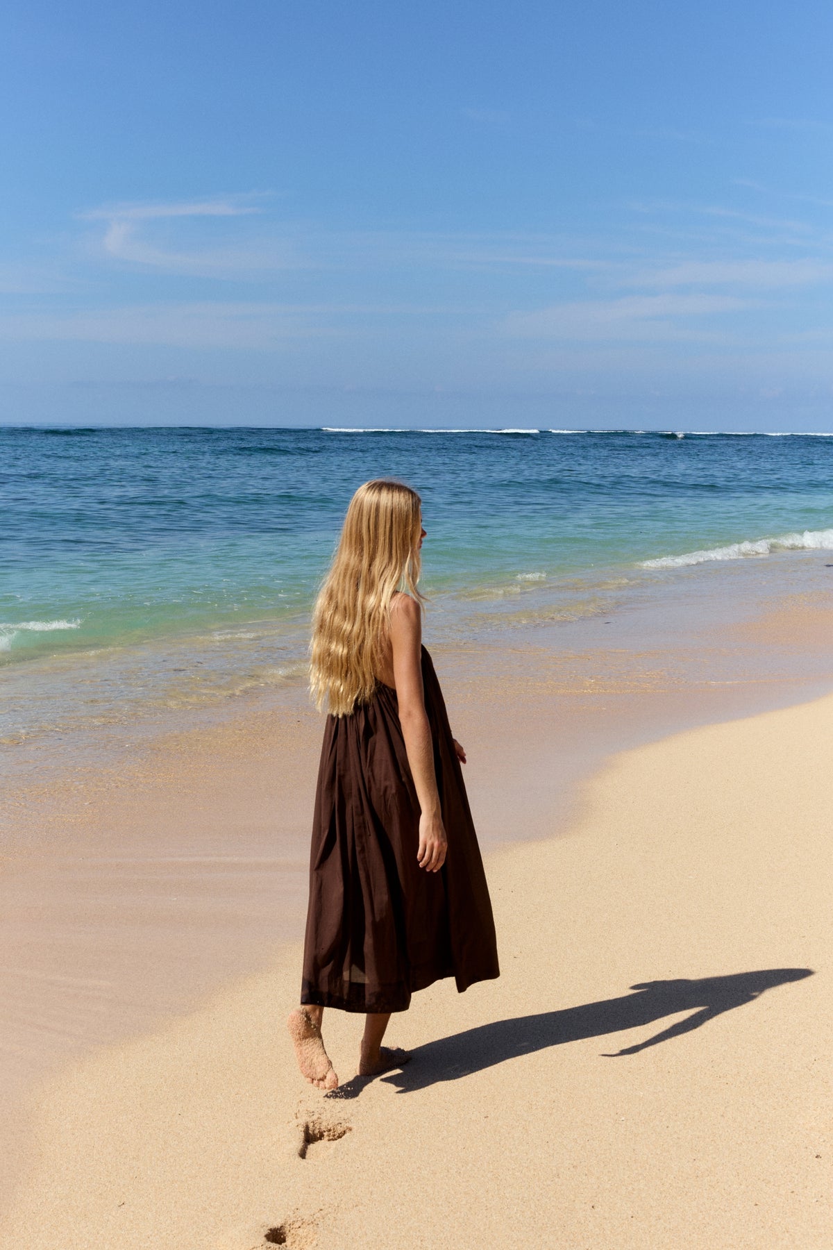 Belle Cotton Midi Dress in Chocolate - walking along the beach, back view - Lilly Pilly Collection