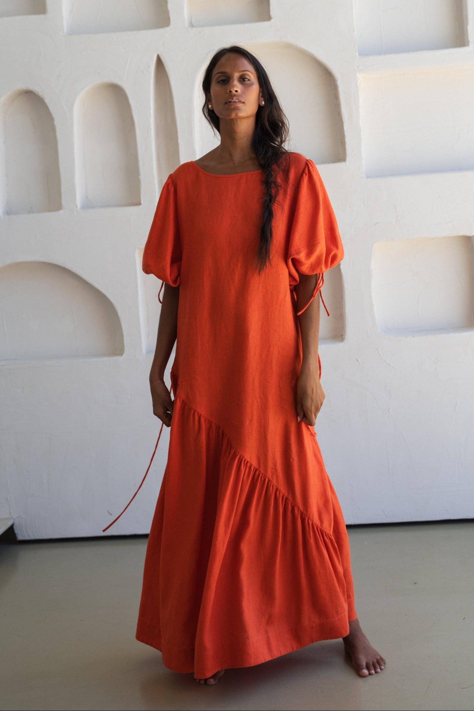 LILLY PILLY woman wearing our spritz Charlotte linen dress against a textured wall