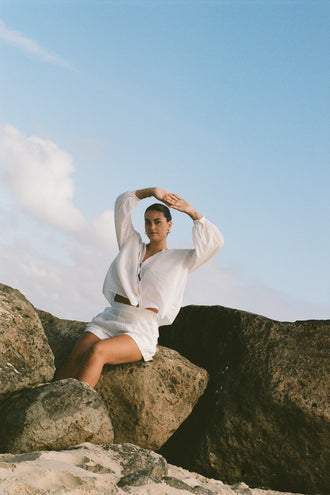 Ember Cotton Voile Shirt in Ivory - front view while sitting on rocks - Lilly Pilly Collection