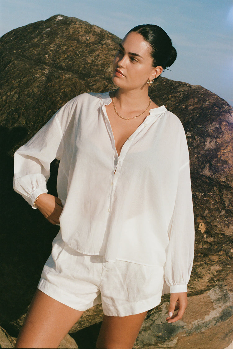 Ember Cotton Voile Shirt in Ivory - front view while standing by a rocky wall - Lilly Pilly Collection