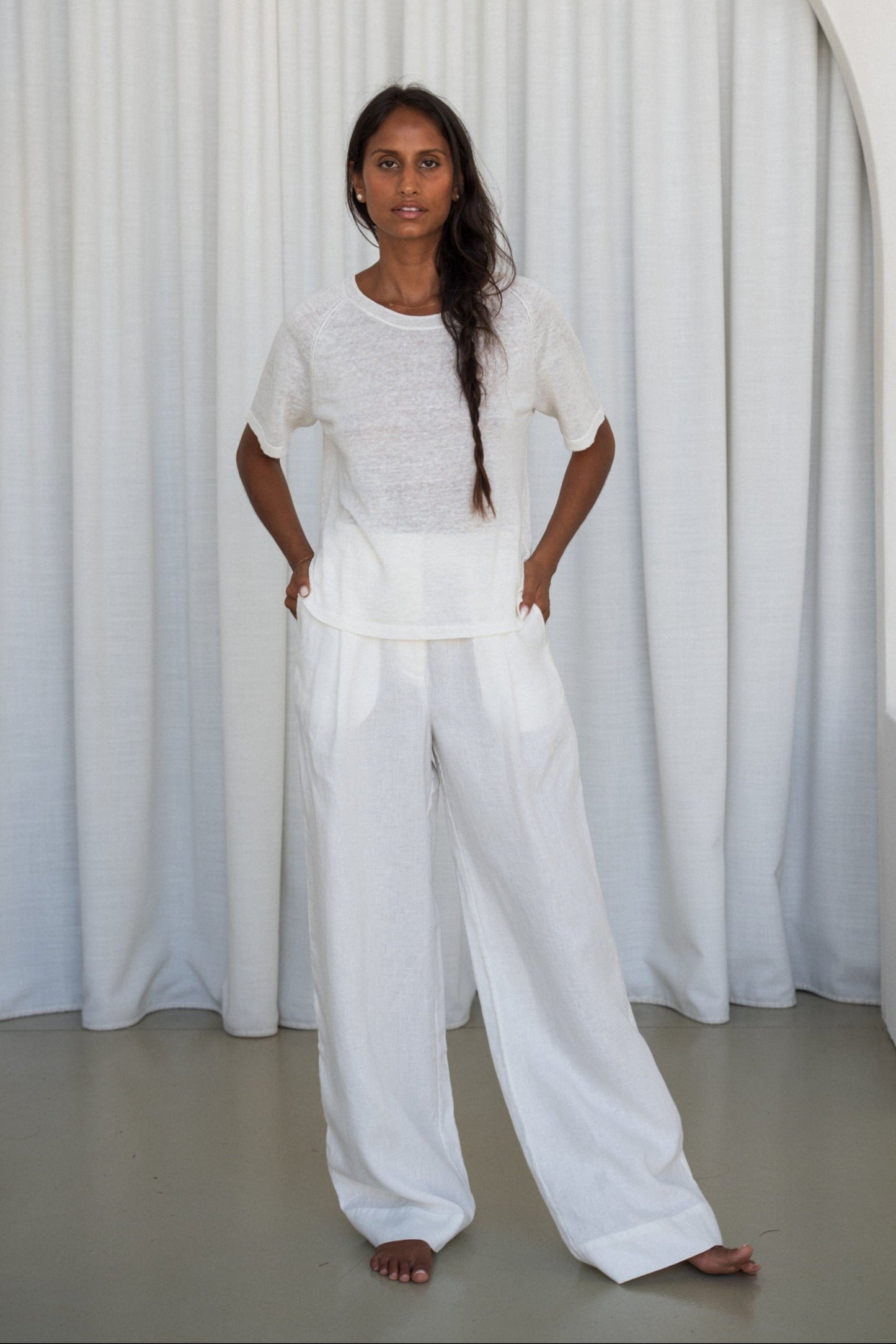 Person wearing a Grace knit top in Ivory and Oli ivory pants set against a plain white background