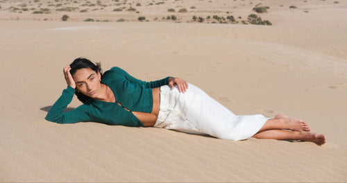 Person lying on sand in a desert landscape