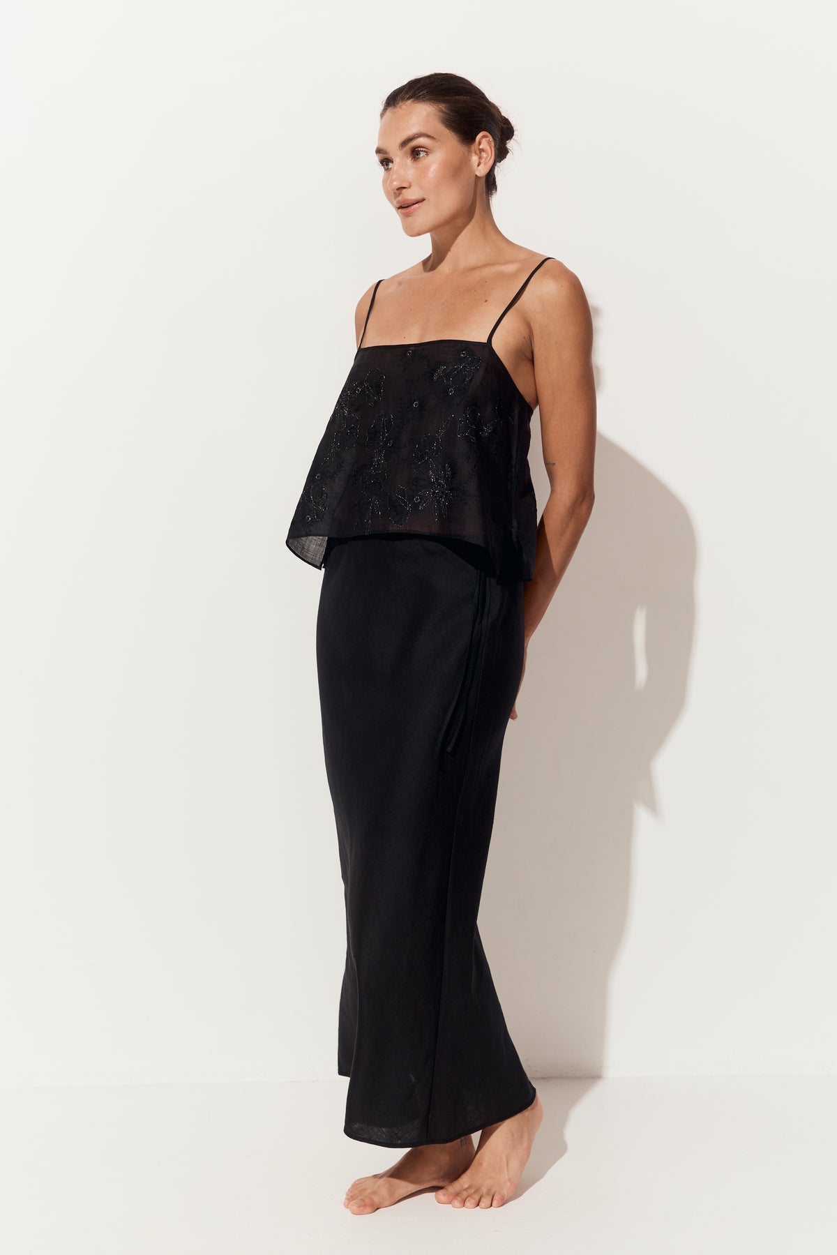 Riley Bias Linen Skirt in Black - angled side view, side tie fastening, white studio backdrop - Lilly Pilly Collection