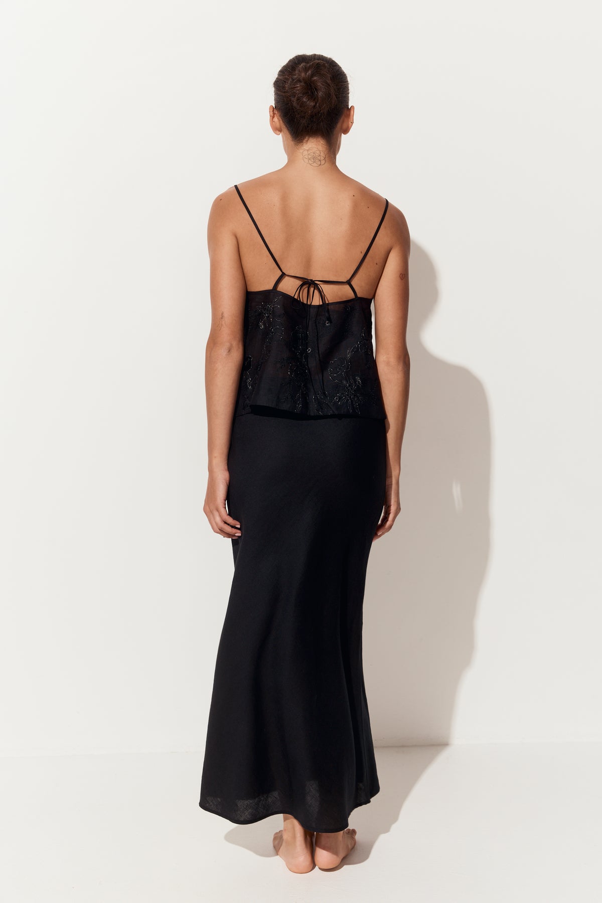 Riley Bias Linen Skirt in Black - back view, flared hem, white studio backdrop - Lilly Pilly Collection