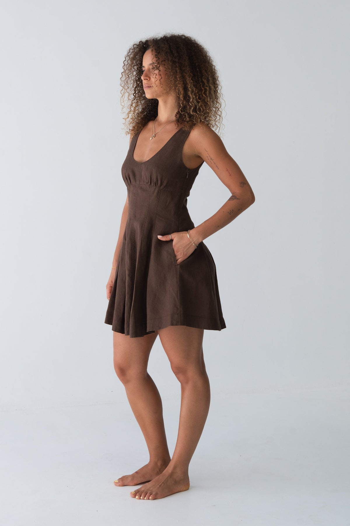 Adele Linen Short Dress in Chocolate - side profile, hand in pocket, fitted bodice and flared dress - Lilly Pilly Collection