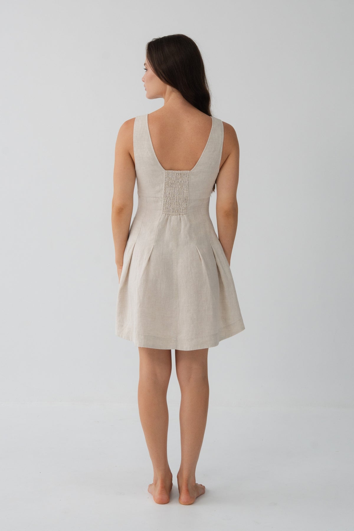 Adele Linen Short Dress in Oatmeal - back view, open scoop back with smocked detail and pleated A-line dress - Lilly Pilly Collection
