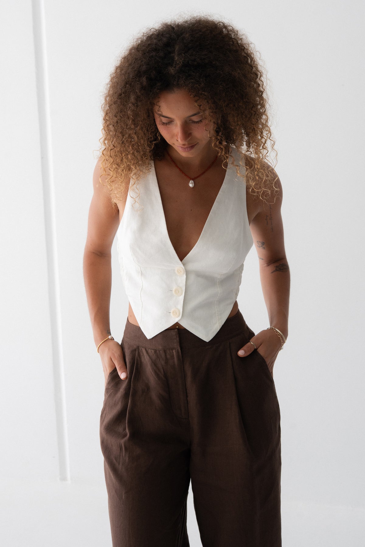 Ari Linen Vest in Ivory - front view, deep V-neckline and button-front with pointed hem - Lilly Pilly Collection