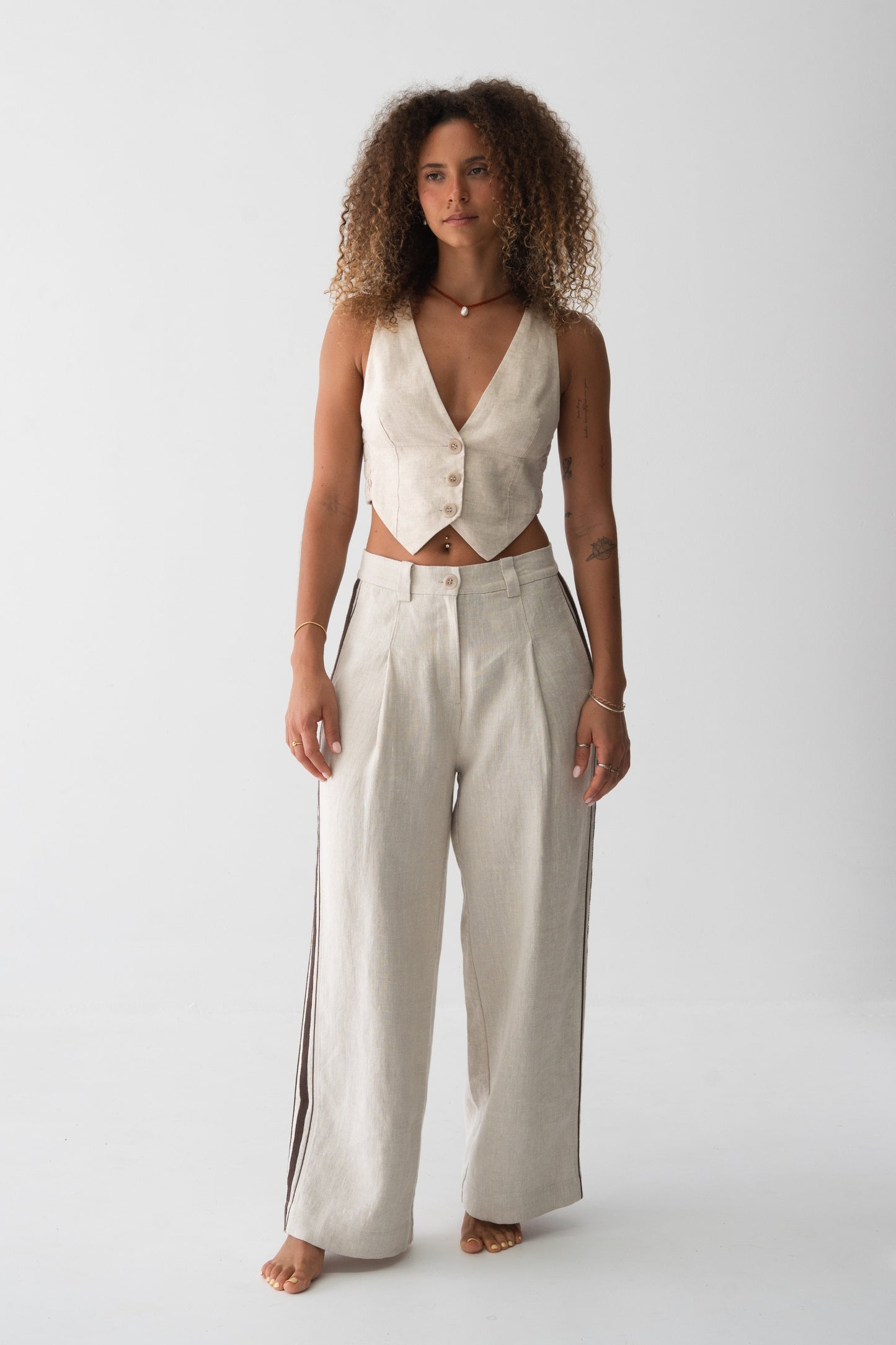 Ari Linen Vest in Oatmeal - front view, V-neckline and button-front with pointed hem, styled with wide-leg linen pants - Lilly Pilly Collection