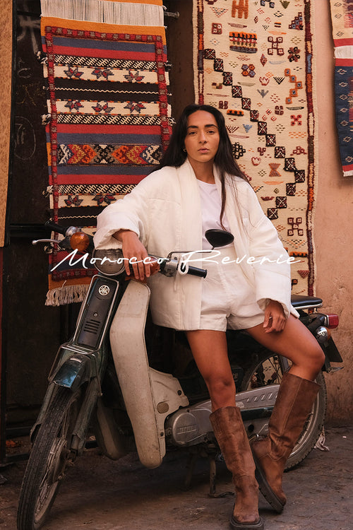 Women wearing Aster Linen puffer jacket in Ivory while sitting on a motorscooter - Lilly Pilly Collection