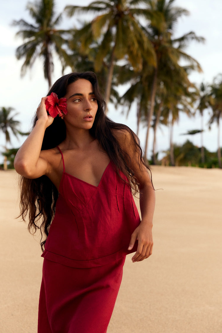 Bea Linen Cami in Cherry Red - woman holding hibiscus flower in hair, V-neckline and spaghetti straps, palm tree beach - Lilly Pilly Collection
