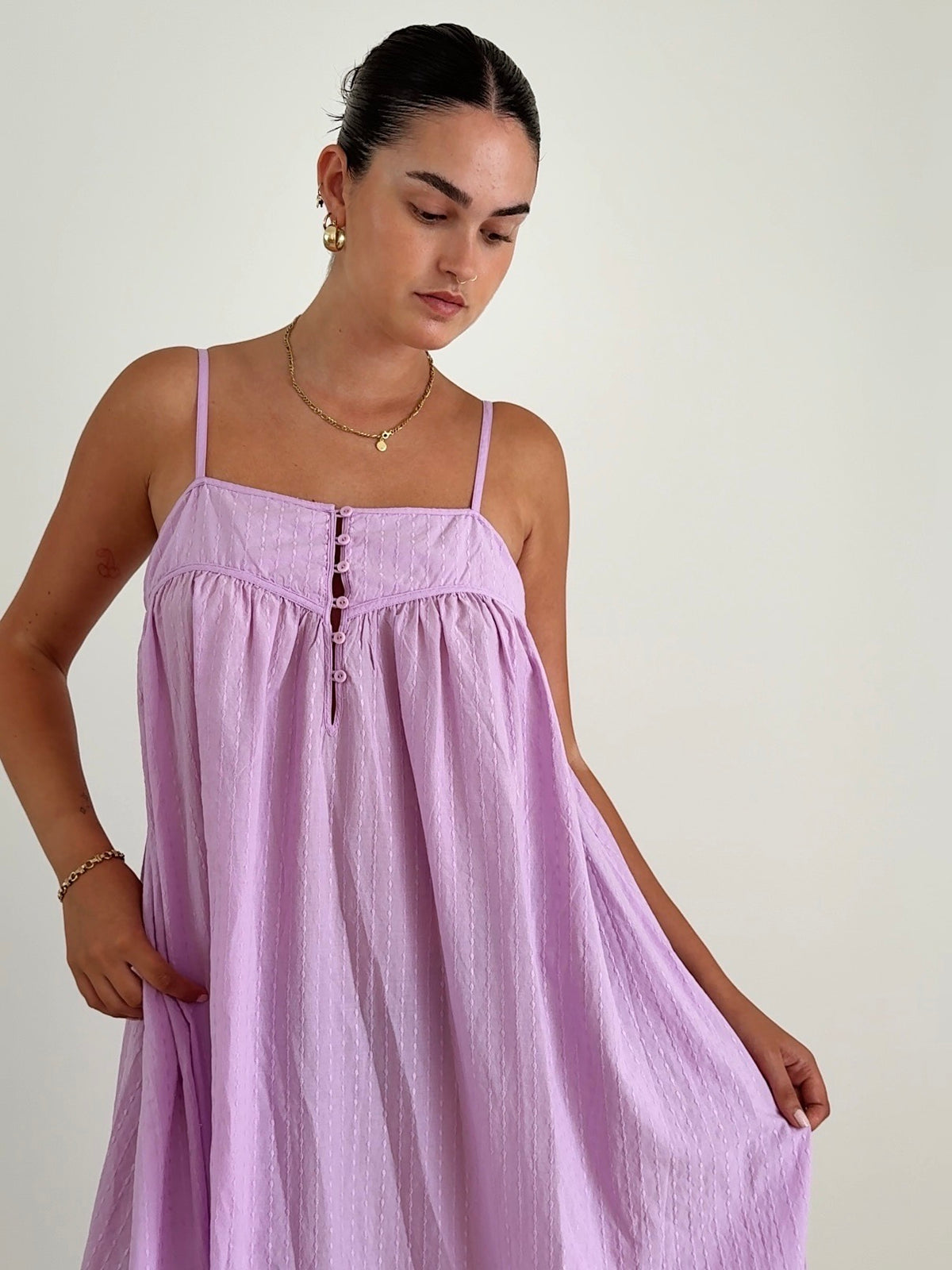 Woman wearing a light purple dress against a plain background