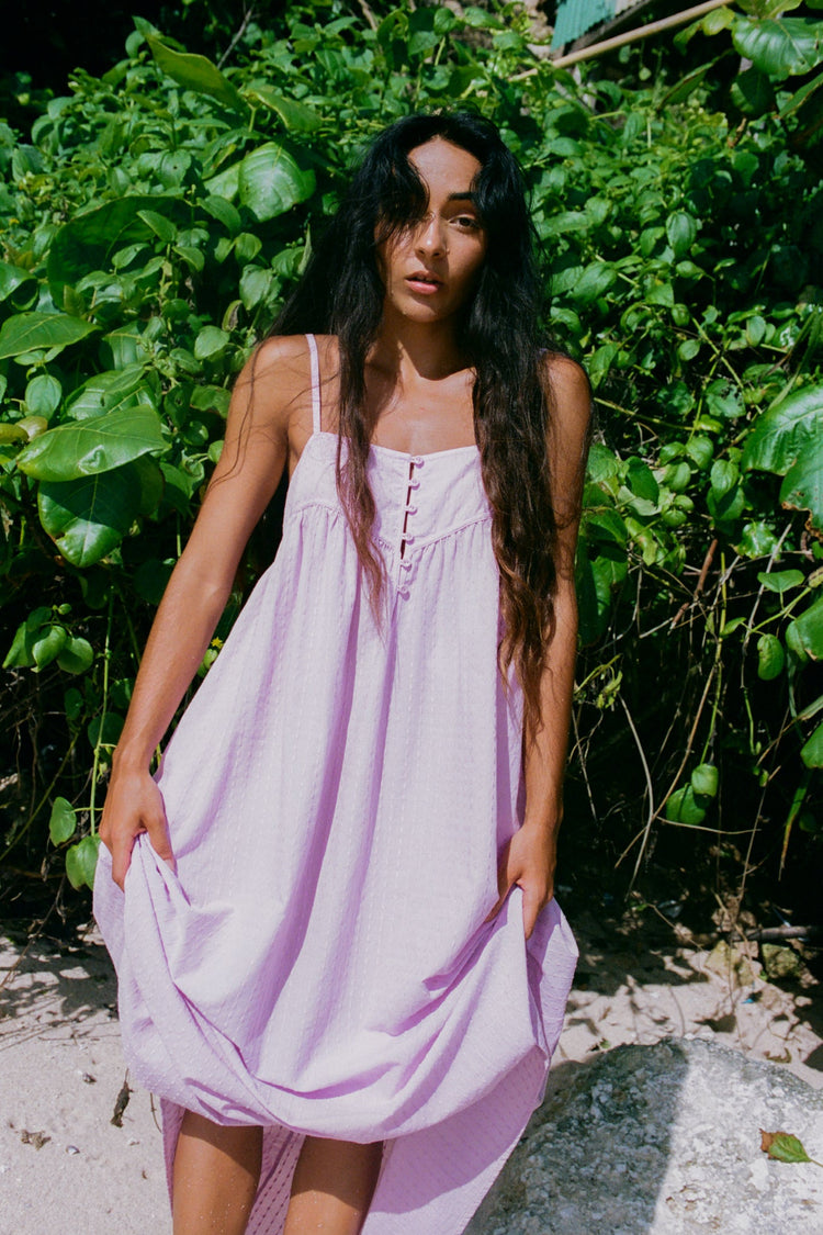 Beatrice Cotton Midi Dress in Orchid - full front view, spaghetti straps and button-front bodice, tropical foliage backdrop - Lilly Pilly Collection