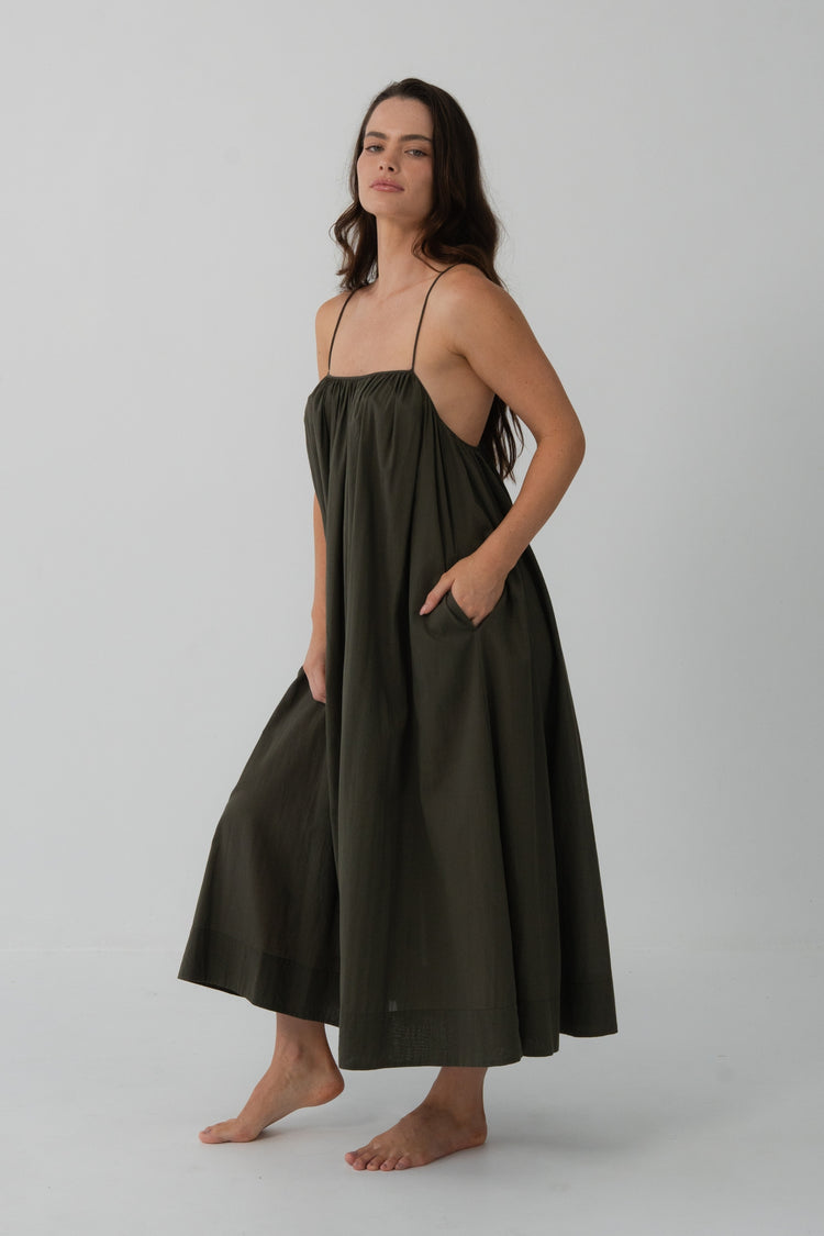 Belle Cotton Midi Dress in Khaki - three-quarter front view, hands in pockets, voluminous midi skirt - Lilly Pilly Collection