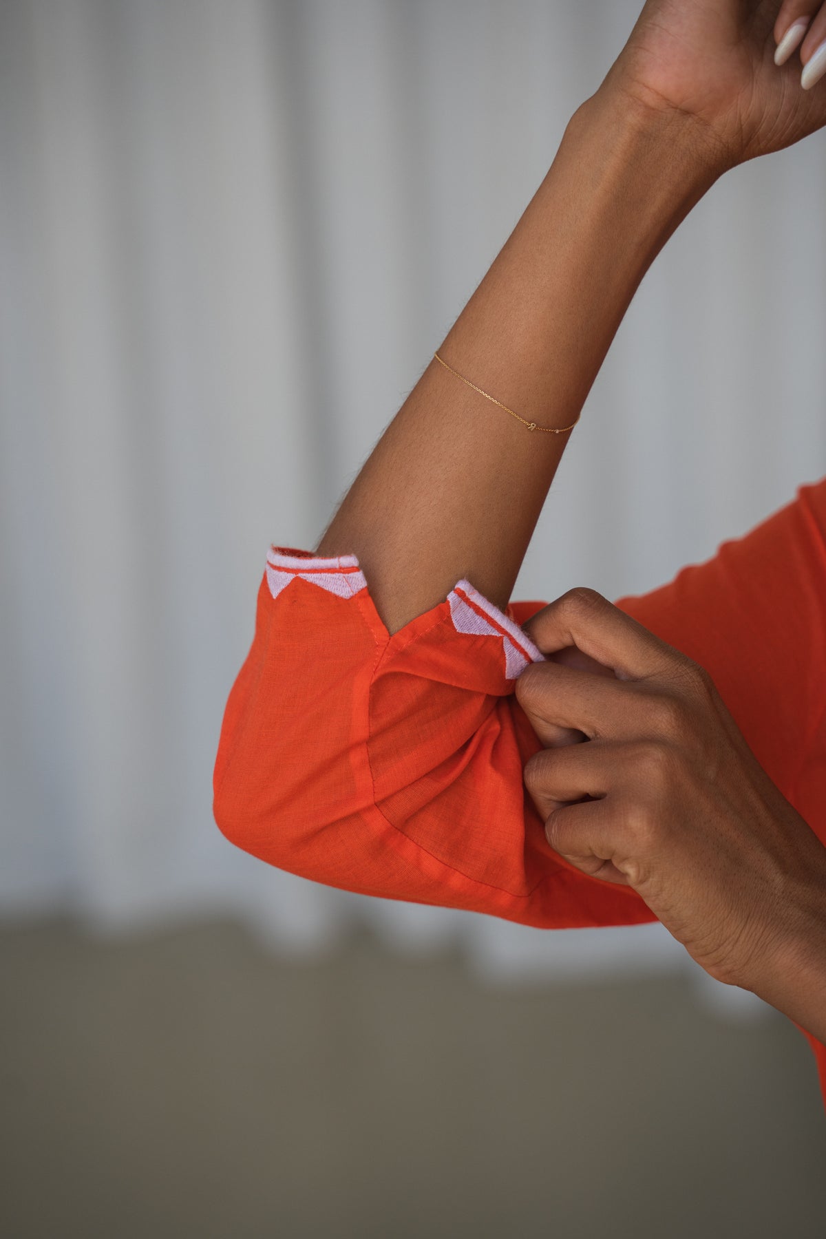 LILLY PILLY woman in a spritz Callie cotton dress showing the sleeve details against a neutral background