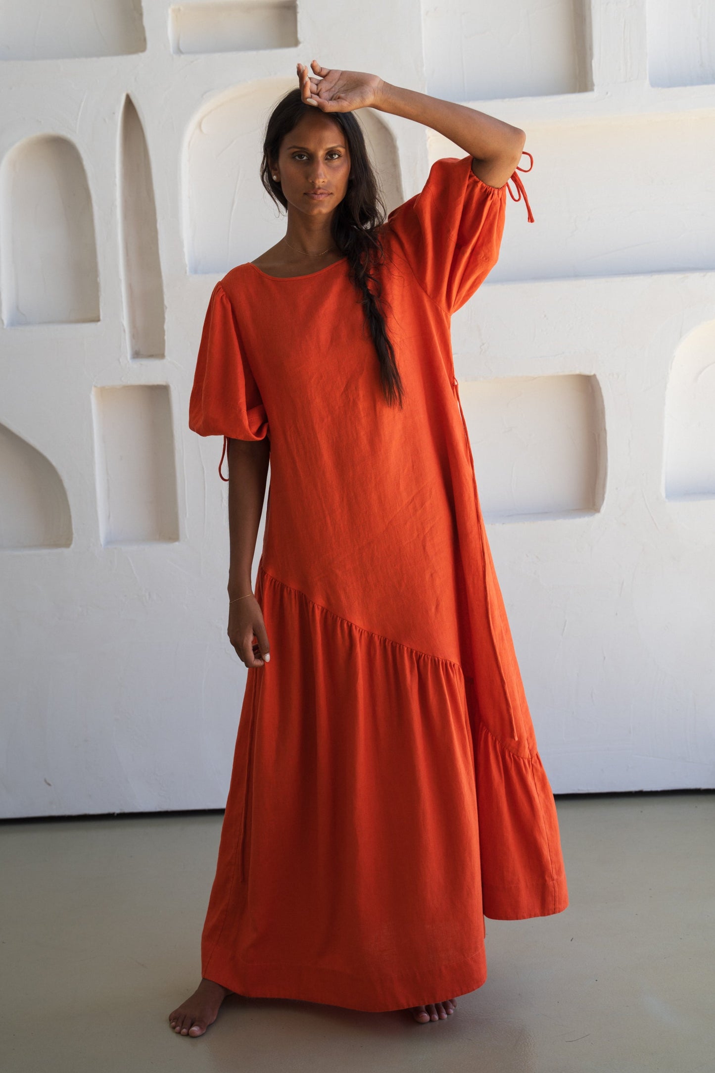 LILLY PILLY woman wearing our spritz Charlotte linen dress against a textured wall