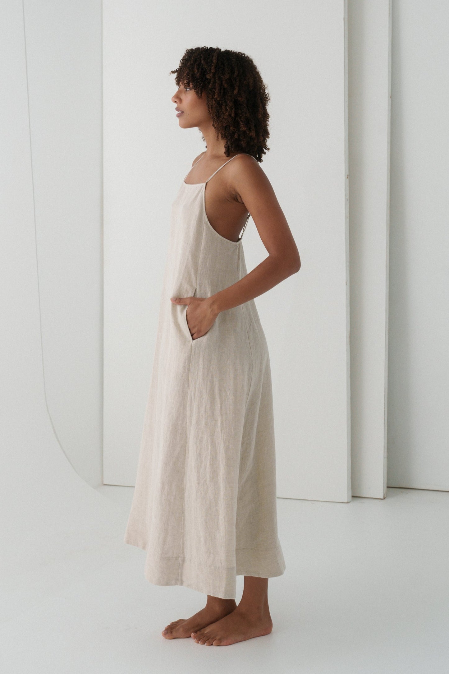 LILLY PILLY woman wearing a oatmeal Coco linen dress showing side view with a white background