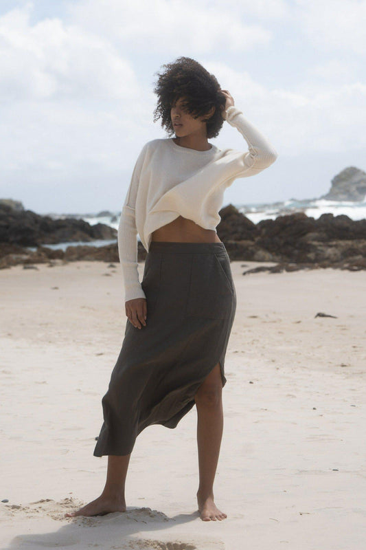 LILLY PILLY Collection Miri Knit made from 95% cashmere and 5% wool in Ivory standing  in front of rocks on a beach