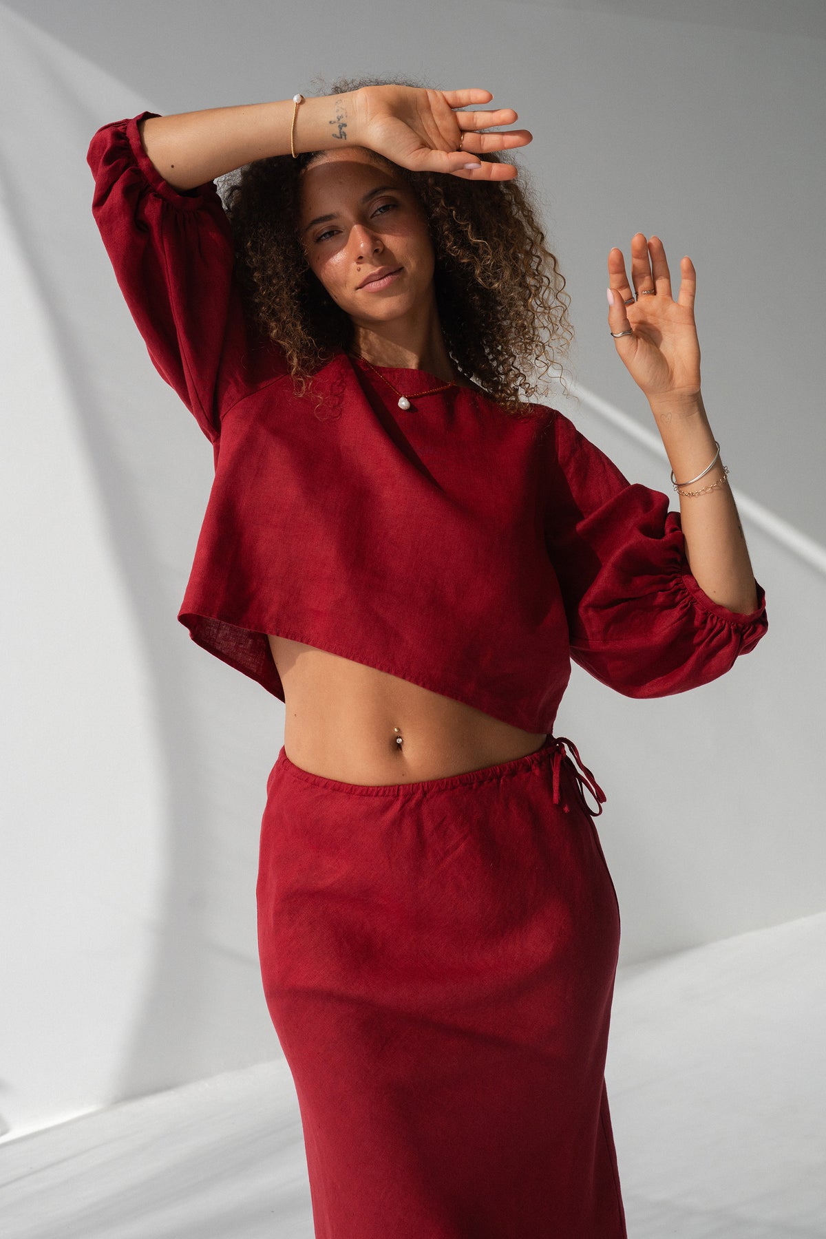 Demi Linen Top in Cherry Red - full length, arms raised, round neckline and puff sleeves, styled with matching Riley Linen Skirt - Lilly Pilly Collection