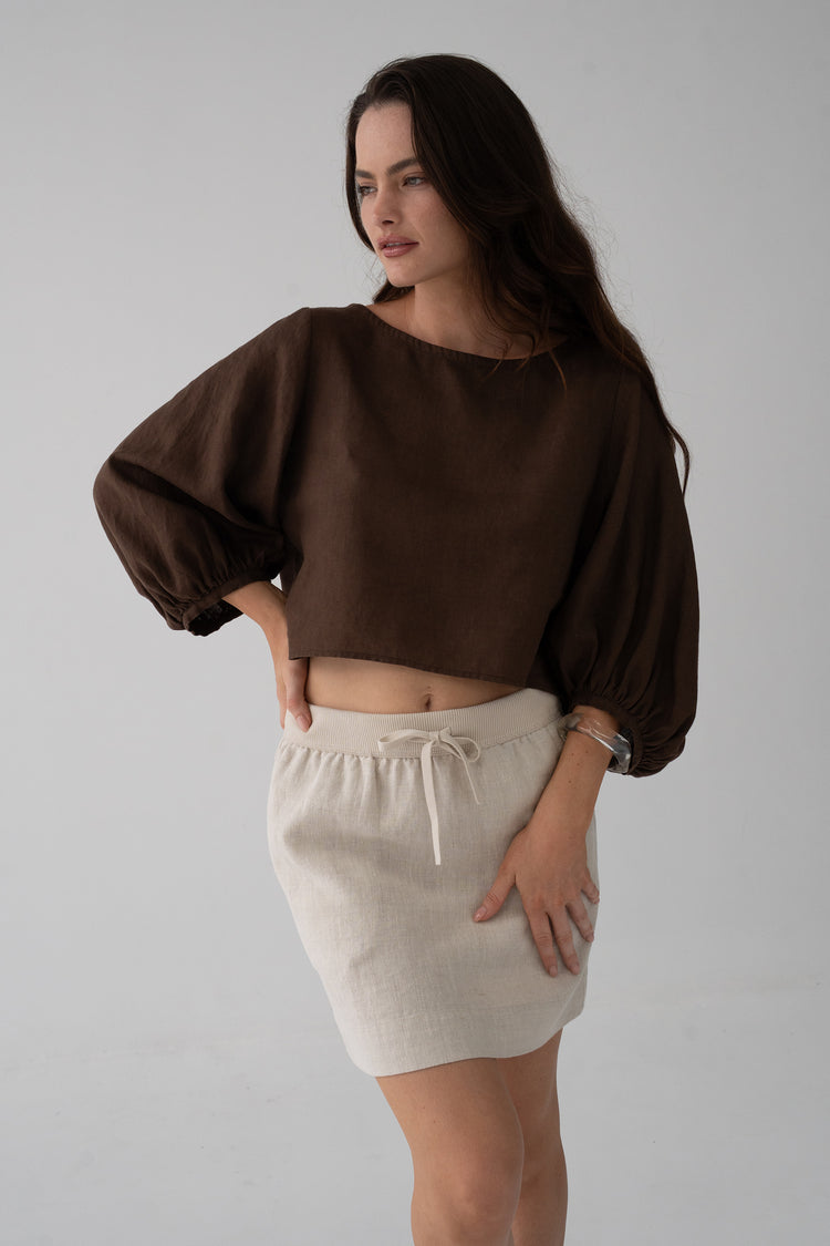 Demi Linen Top in Chocolate - three-quarter view, round neckline and puff sleeves, styled with oatmeal knit mini skirt - Lilly Pilly Collection