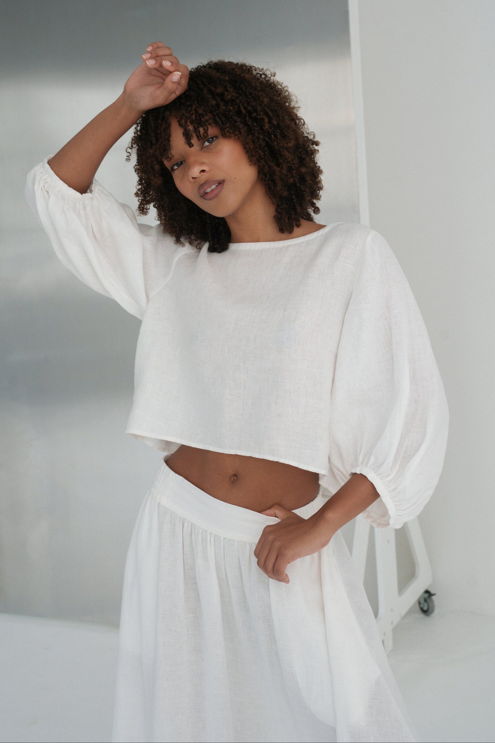 LILLY PILLY woman wearing an ivory Demi linen top and Hannah skirt outfit in a minimalistic setting