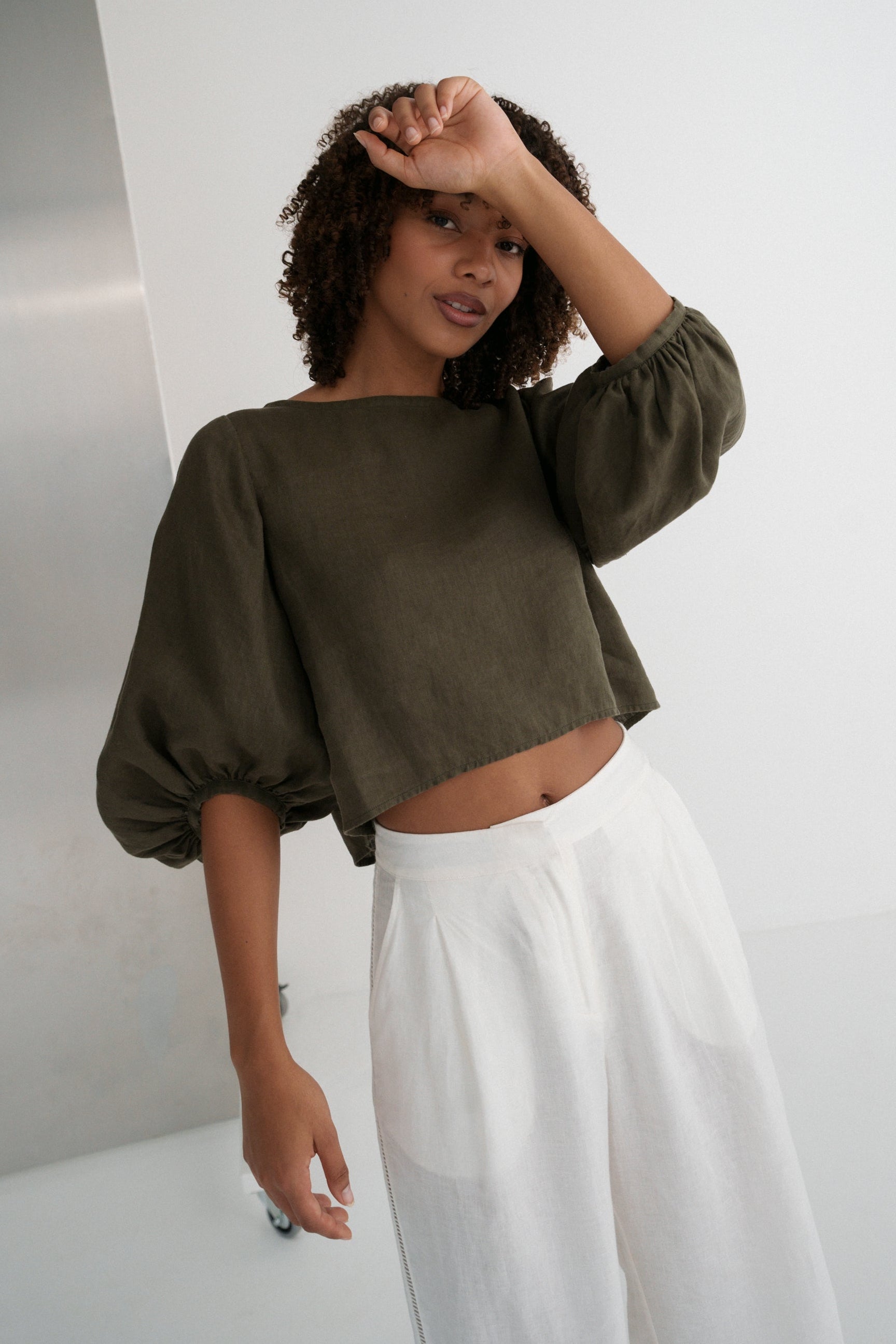 LILLY PILLY woman wearing a khaki green Demi linen top and ivory Ivy linen pants against a white background