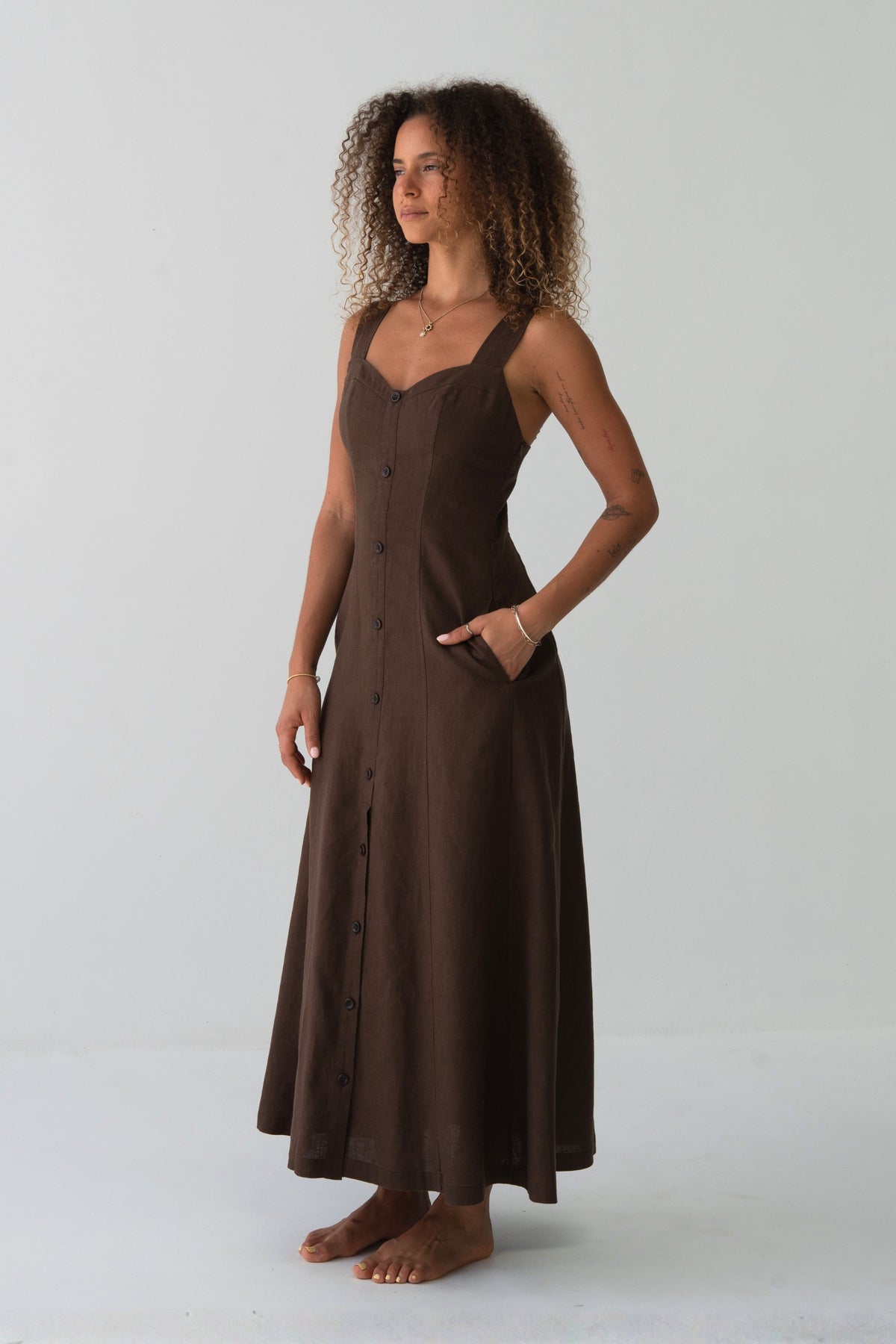 Eden Linen Midi Dress in Chocolate - side profile, hand in pocket, sweetheart neckline and A-line midi silhouette - Lilly Pilly Collection