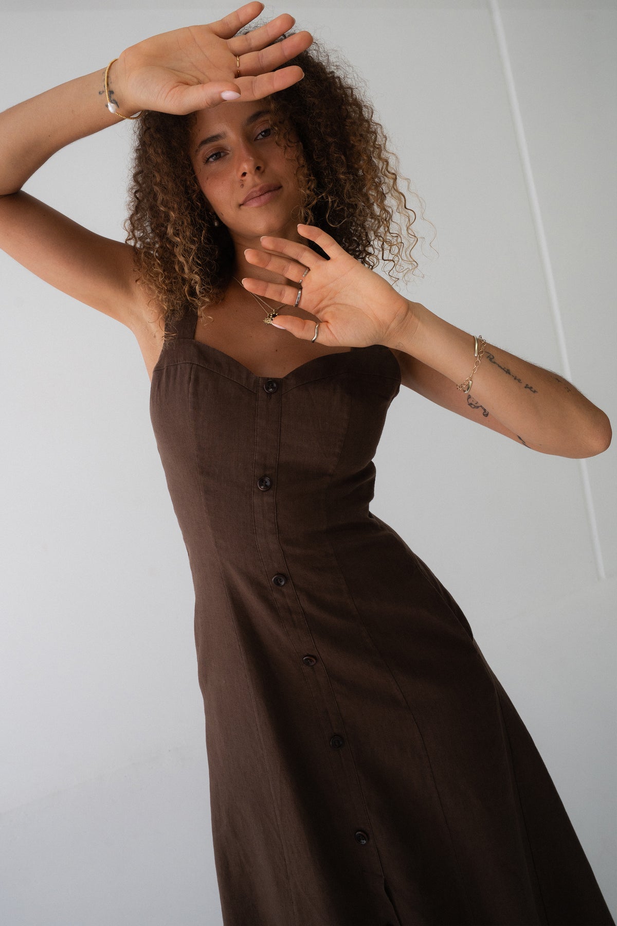 Eden Linen Midi Dress in Chocolate - close-up of sweetheart neckline and button-front placket, arms raised - Lilly Pilly Collection