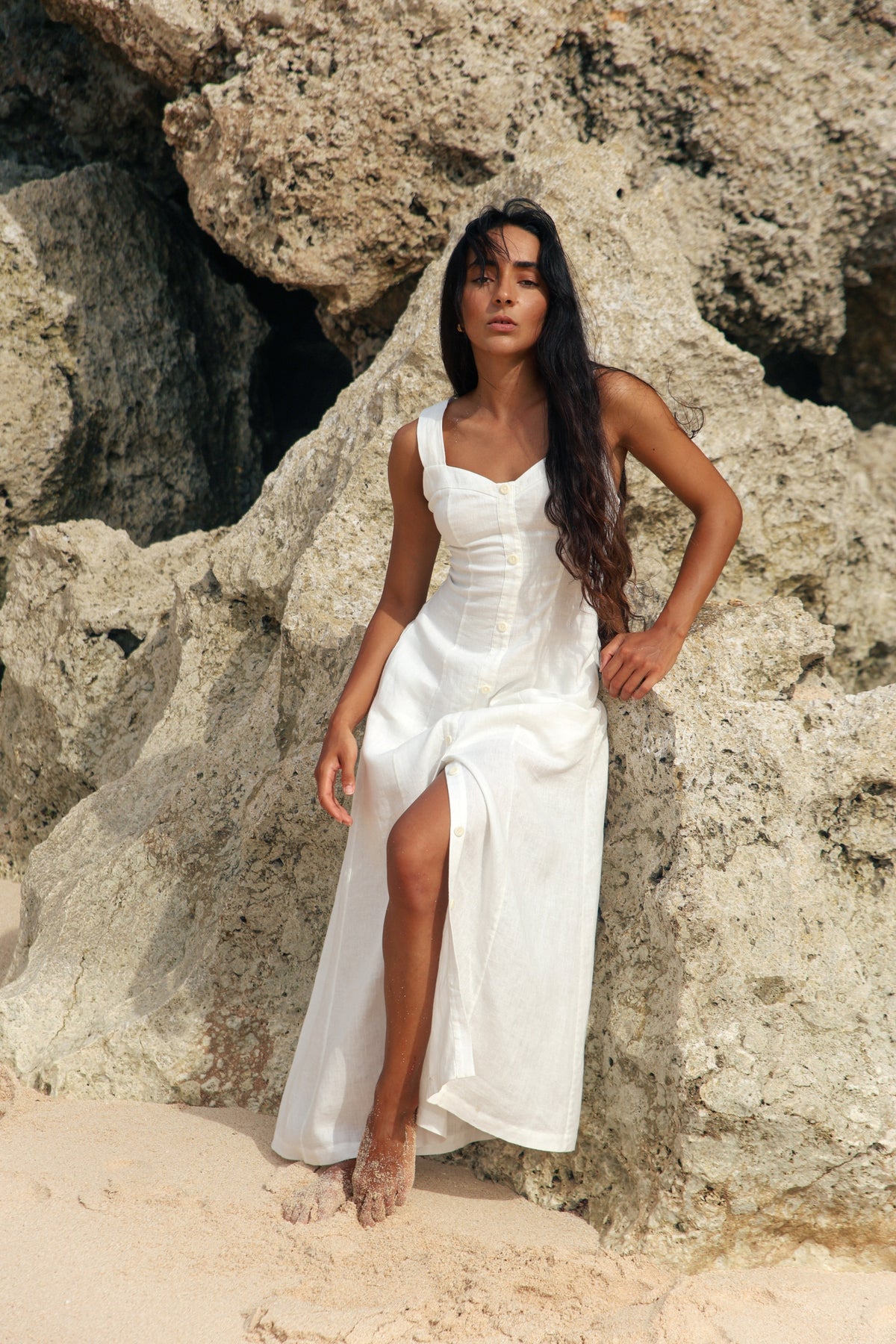 Eden Linen Midi Dress in Ivory - full length view, sweetheart neckline, button-front placket and side split, beach rocks backdrop - Lilly Pilly Collection