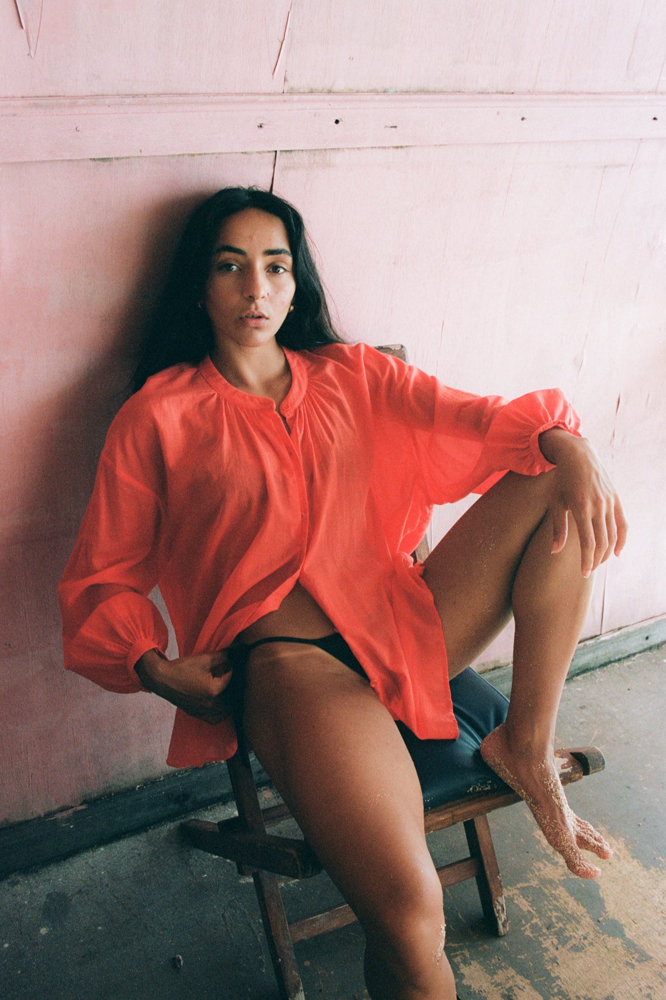 LILLY PILLY woman wearing a spritz Ember cotton voile shirt sitting against a pink wall