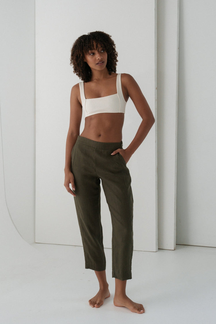Emer Linen Pants in Khaki - full length front view, woman wearing Khaki tapered linen pants with ivory square-neck crop bra top, studio backdrop - Lilly Pilly Collection