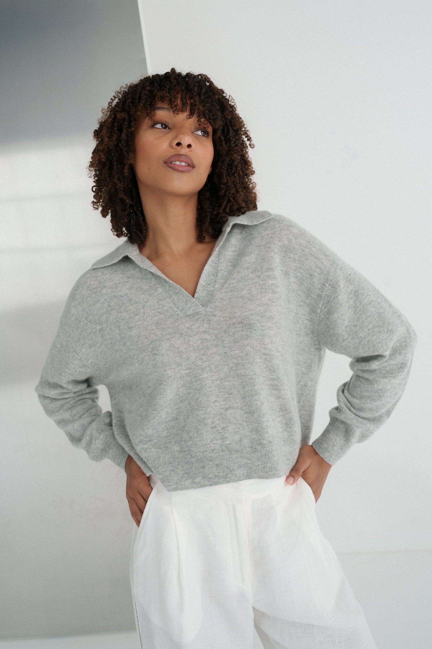 LILLY PILLY woman wearing a grey marle Emma cashmere merino knit sweater and ivory white Ivy linen pants against a neutral background