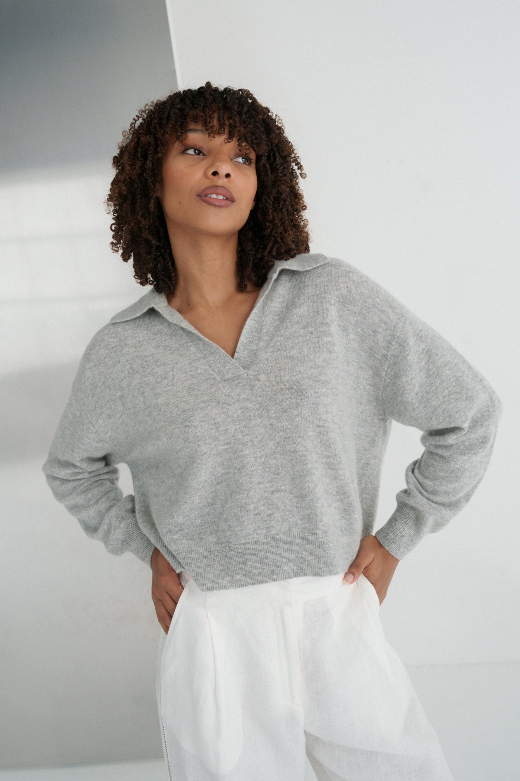LILLY PILLY woman wearing a grey marle Emma cashmere merino knit sweater and ivory white Ivy linen pants against a neutral background
