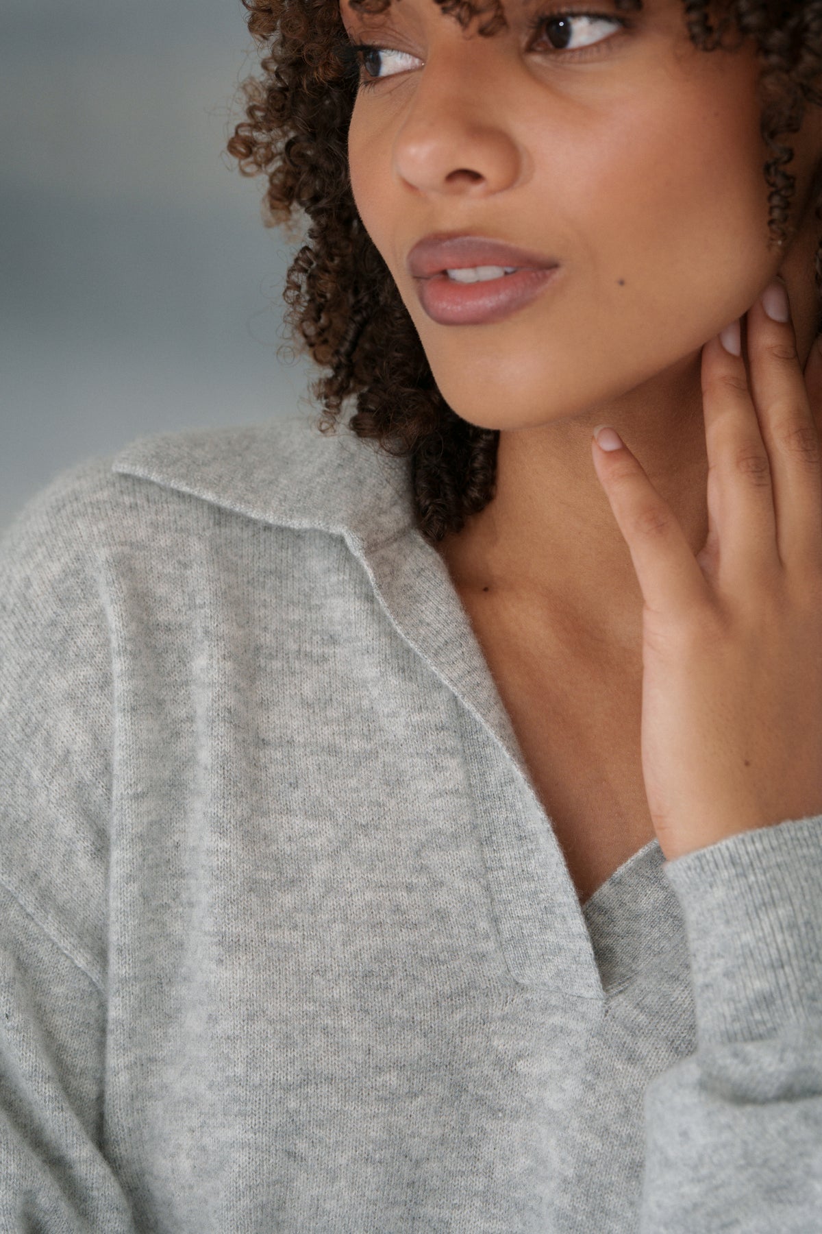 Close up of LILLY PILLY woman wearing a grey marle coloured Emma cashmere merino knit sweater with a neutral background