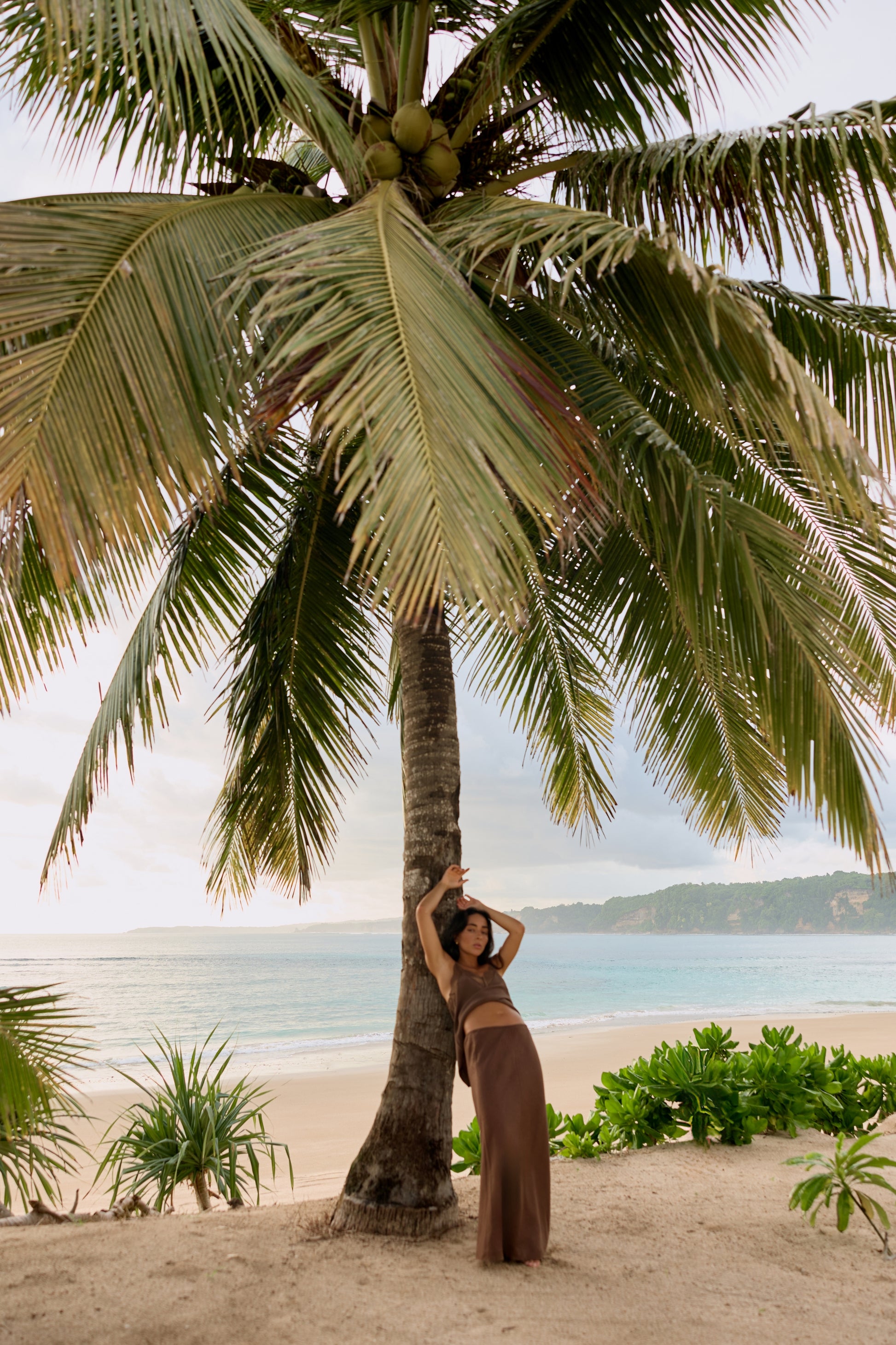 Frankie Silk Cami in Chocolate - full length, arm raised against palm tree, styled with matching linen maxi skirt, tropical beach - Lilly Pilly Collection