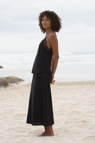 Frankie Silk Cami in Black - side profile, spaghetti straps and lace trim, styled with black Riley Linen Skirt, beach - Lilly Pilly Collection